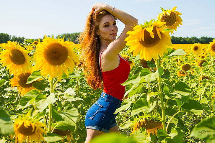 cute redhead in field of sunflowers