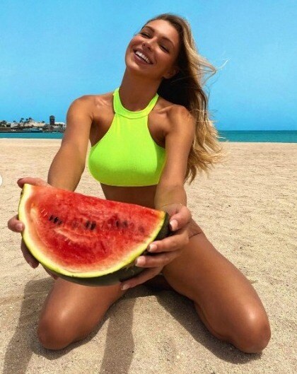 cute woman in yellow top holding watermelon slice