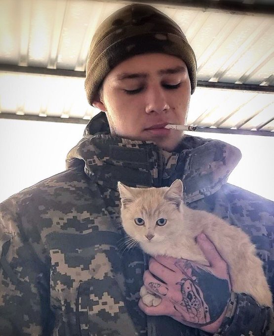 a Ukrainian soldier with an orange cat