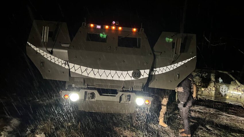 HIMARS with nose and door art of a dinosaur grinning