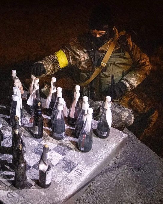 A Ukrainian soldier plays checkers with Molotov cocktails as the pieces.