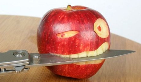 apple carved into a pirate head, with a knife in its teeth