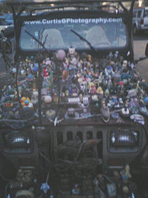 art Jeep with a bunch of plastic toys glued to it