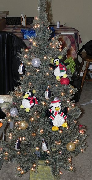 Christmas tree with a bunch of penguin ornaments hanging from it