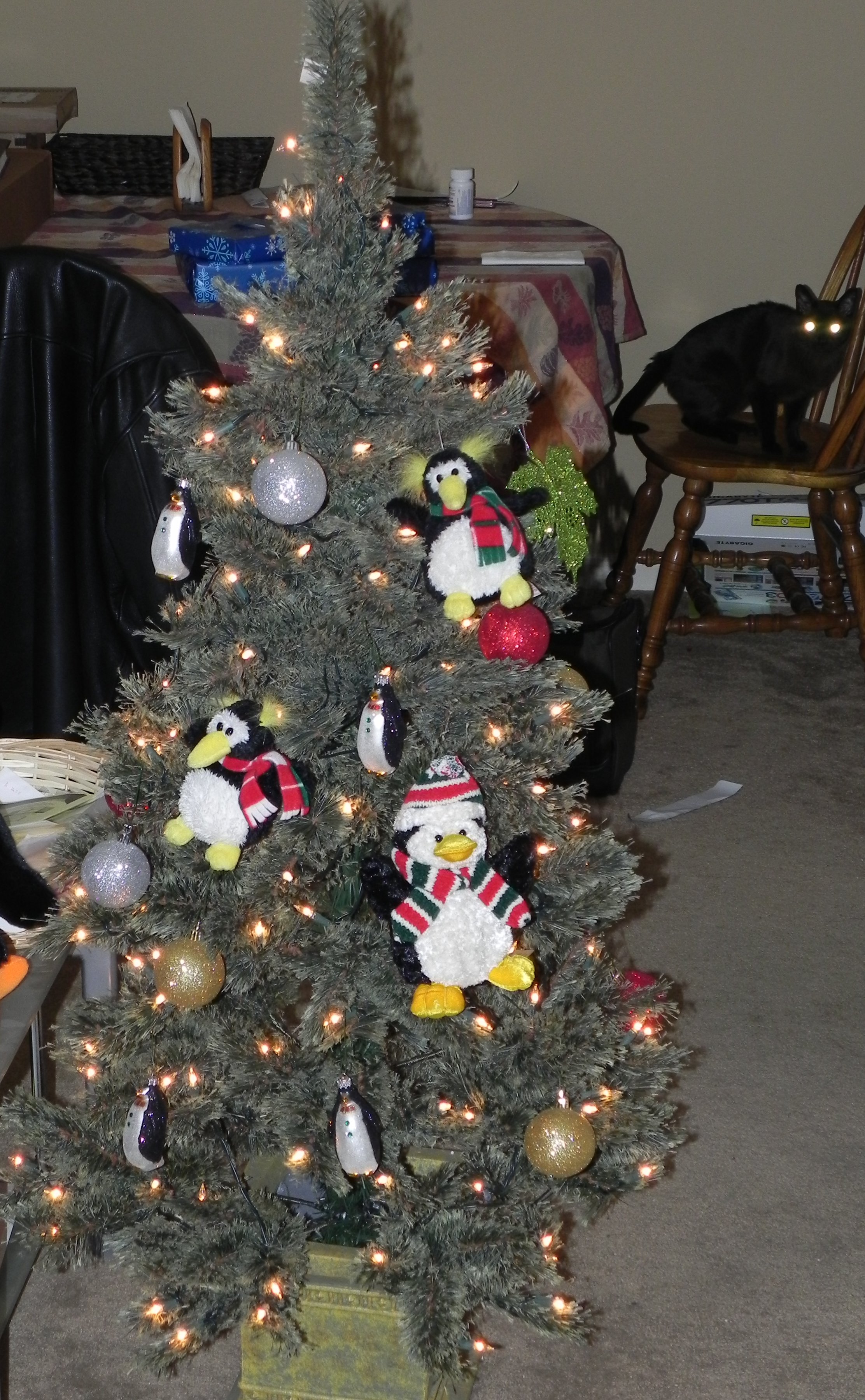 Christmas tree with a bunch of penguin ornaments hanging from it