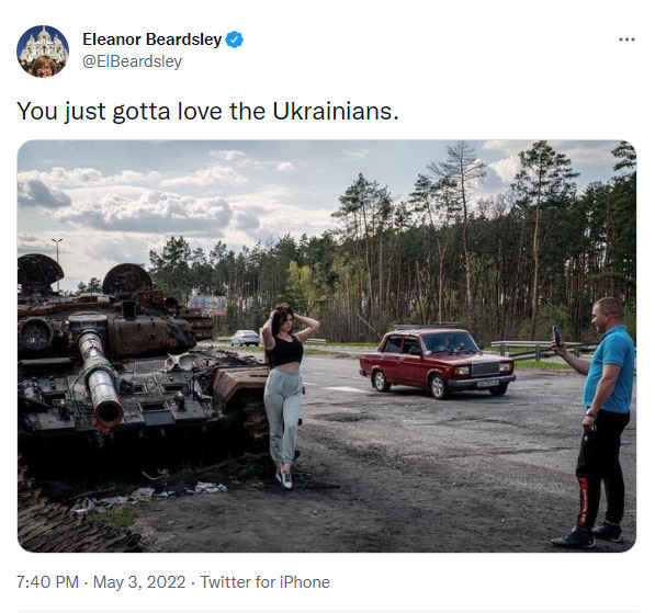 cute Ukraine woman poses by destroyed Russian tank