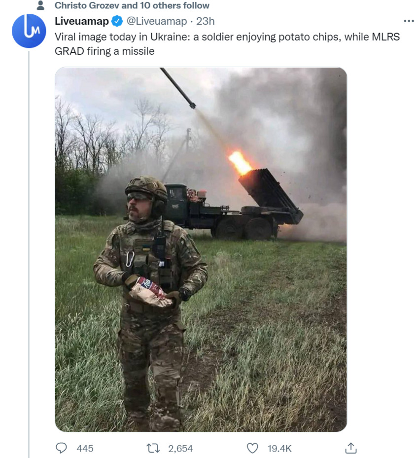 soldier enjoys potato chips while MLRS GRAD firing a missile