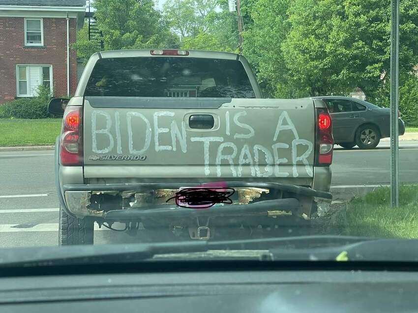 pickup truck with hand-painted 'Biden is a trader' on its tailgate