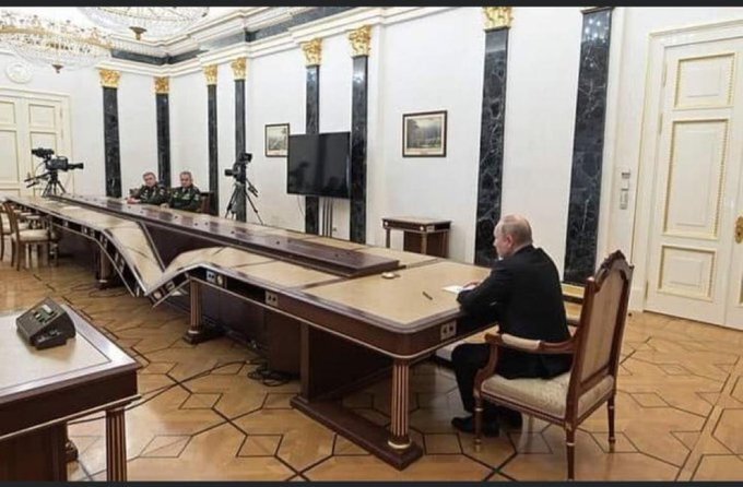 Putin at his very long table, but the table has been shopped so that it's broken just like the Kerch bridge