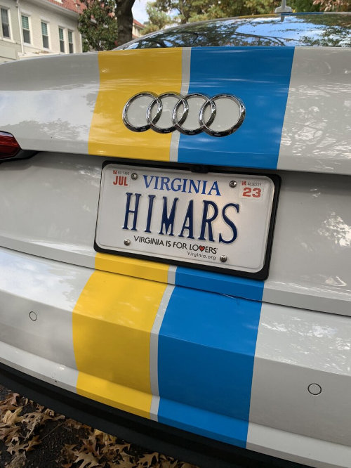 Car with blue and yellow racing stripes and HIMARS license plate