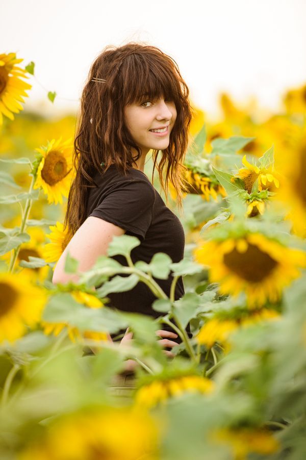 cute brunette in field of sunflowers