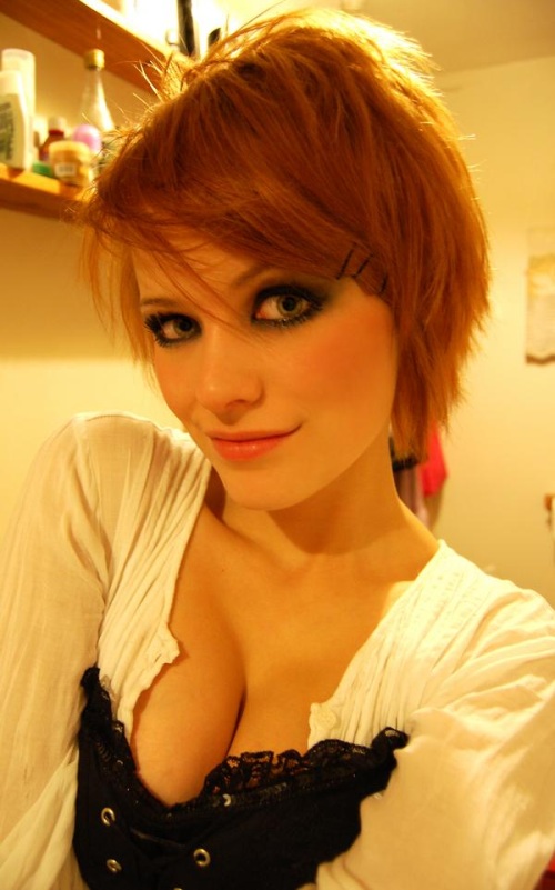 redhead with devilish smirk and wide green eyes